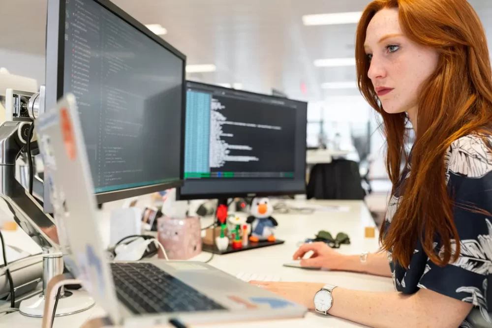 A woman in an office researching RFP automation tools on her computer